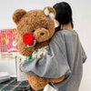 24. Teddy Bear Wearing a Shirt Holding Flowers