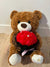 6. A Brown Bear Sits Holding Flowers