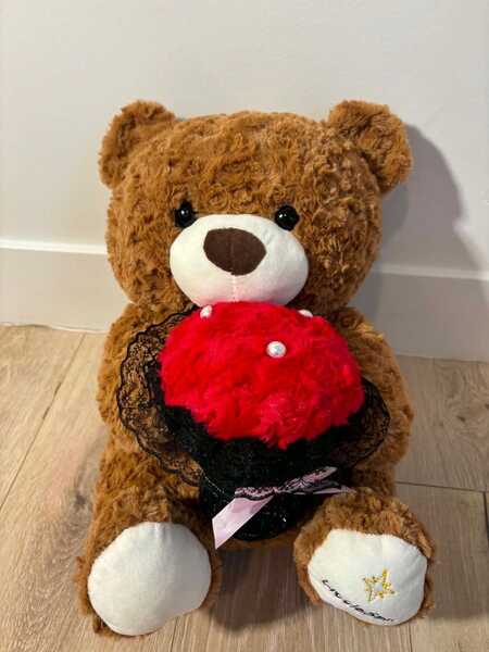 6. A Brown Bear Sits Holding Flowers